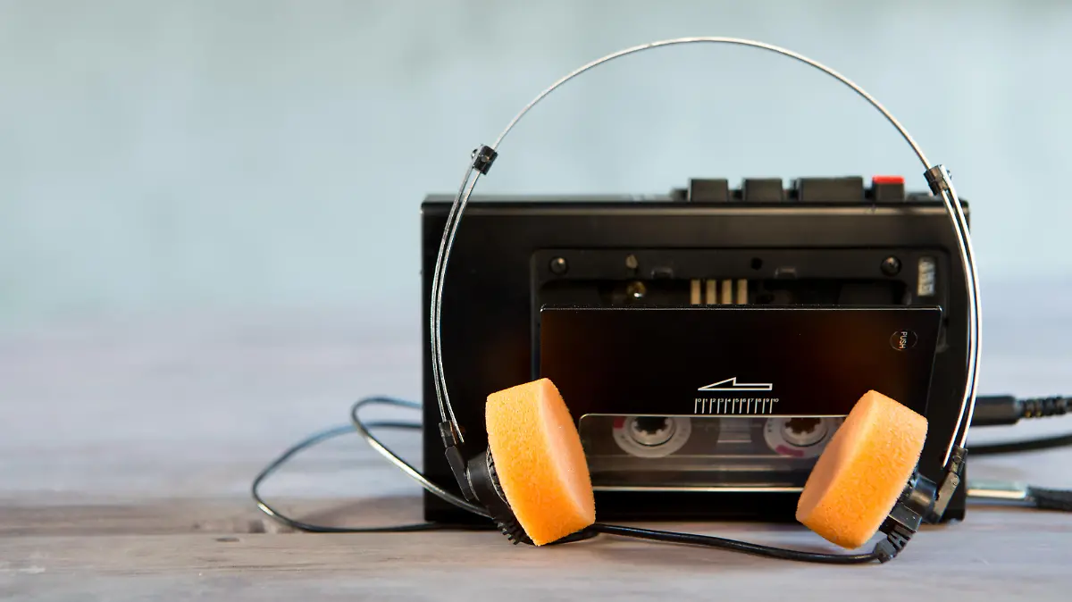 Old portable cassette player and headphones on a abstract background. Vintage advertisement style