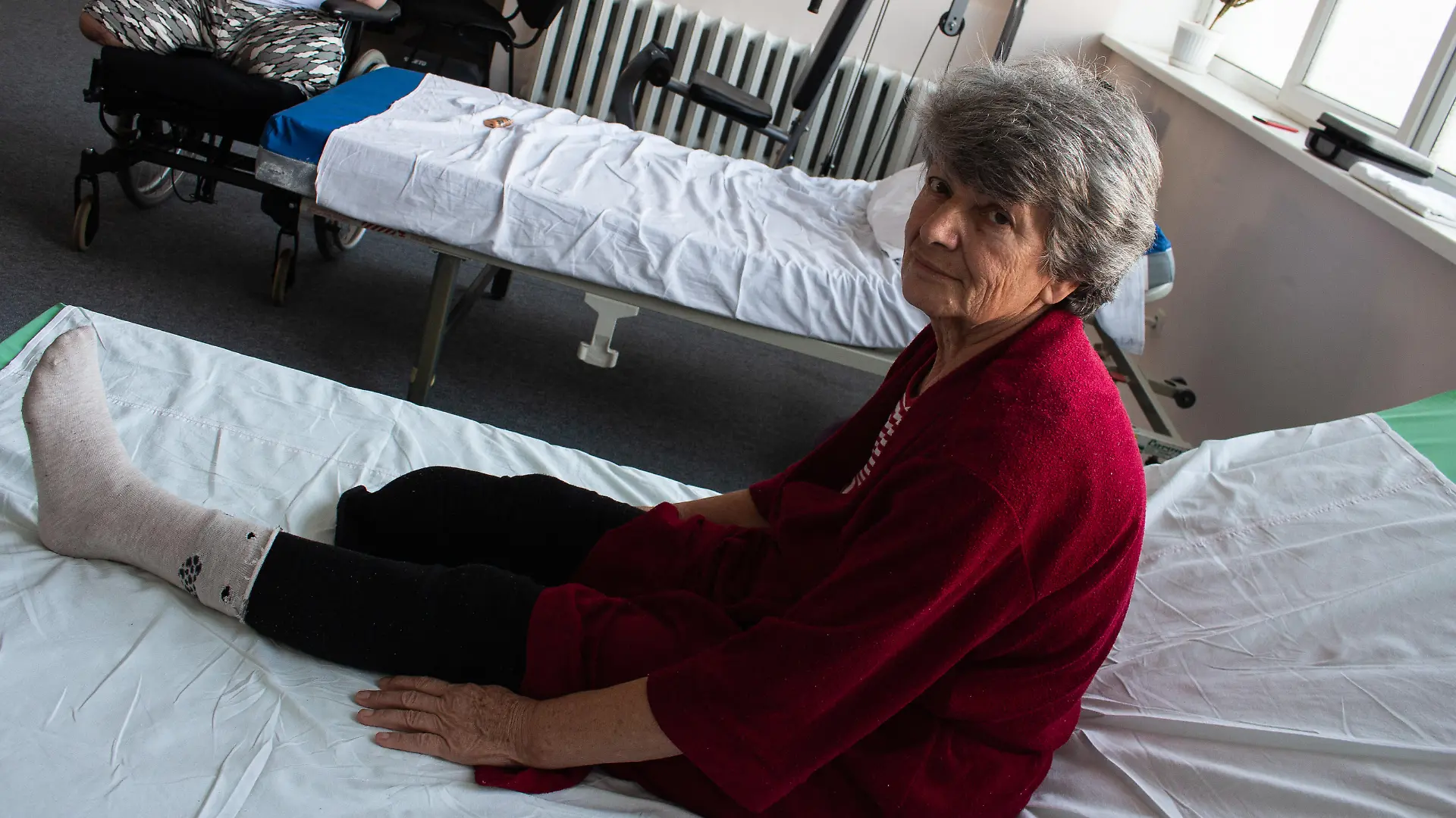 Tetyana Voytenko, a patient with an amputated right leg, from Izyum, Kharkiv region. She is being treated by MSF physiotherapists in Vinnytsia.
"When the Russians fled from Izyum, they covered the whole city with tiny petal mines: backyards, gardens and walking paths. I go to the forest to collect firewood so that I could use as a source for heating. It wasn't the first time I walked that path but it was the time when I stepped on that petal mine. Half of the right leg was torn off. I was together with my neighbor Nadia, and her goats. They walked ahead, passing all the trouble but it didn’t pass me. I keep feeling severe phantom pains, but when the wound heals, I will ask for a prosthesis, for now - I can move around only on crutches.