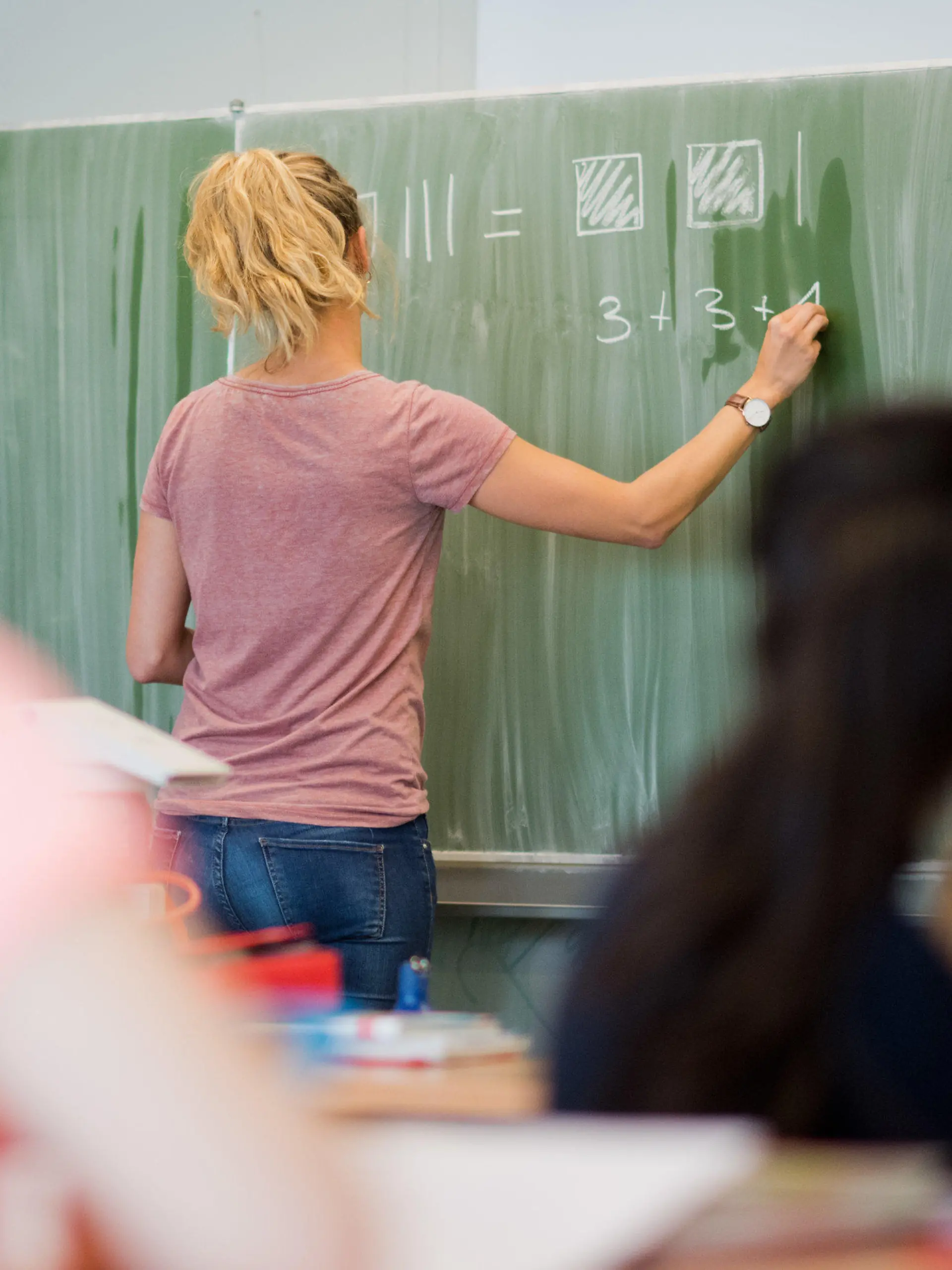 ARCHIV - 17.08.2016, Niedersachsen, Hannover: Eine junge Lehrerin schreibt an einer Schultafel im Mathematikunterricht einer 8. Klasse an einer Integrierten Gesamtschule. Lehrermangel bleibt weiterhin ein Problem an vielen niedersächsischen Schulen. Auf Antrag der FDP-Fraktion wird sich der Landtag am Mittwoch (12.09.2018) mit der Frage befassen, ob Niedersachsens Kultusminister genug unternimmt, um die Situation zu verbessern. Foto: Julian Stratenschulte/dpa +++ dpa-Bildfunk +++