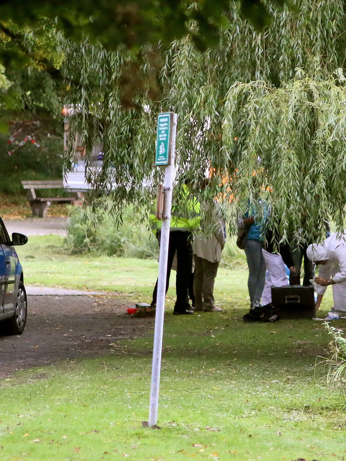 HANDOUT - Polizei- und Ermittlungsbeamte arbeiten am 23.09.2015 am Fundort einer Leiche am Stadtpark-Teich in Salzgitter (Niedersachsen). Mitarbeiter des städtischen Entsorgungsbetriebs hatten dort eine in Müllsäcken verpackte männliche Leiche entdeckt. Foto: Salzgitter Zeitung/Alexandra Ritter/dpa (zu lni «Leiche im Stadtpark von Salzgitter entdeckt» vom 23.09.2015) (Achtung Redaktionen: Verwendung nur zu redaktionellen Zwecken im Zusammenhang mit der aktuellen Berichterstattung und bei vollständiger Nennung der Quelle: Salzgitter Zeitung/Alexandra Ritter) +++(c) dpa - Bildfunk+++