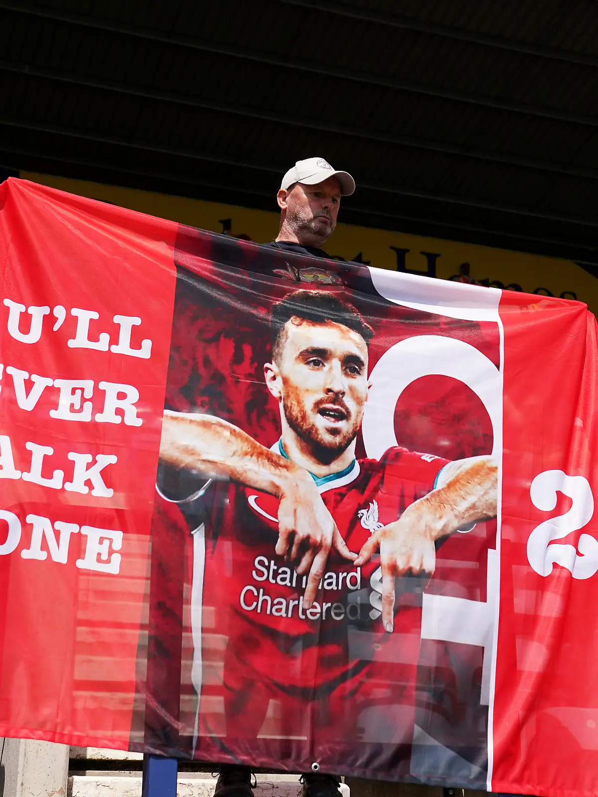 Ein Liverpool-Fan erinnert mit einer Fahne an Diogo Jota.