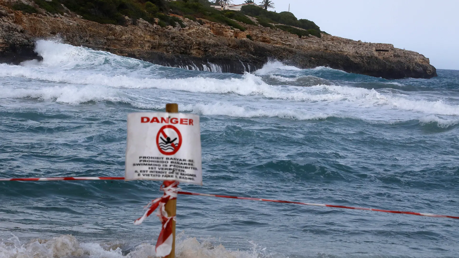 02.09.2021, Spanien, Manacor: Ein Schild verbietet das Schwimmen am Strand von Cala Mendia in Manacor auf Mallorca. Zwei junge Urlauberinnen aus Nordrhein-Westfalen sind hier im Meer vor Mallorca ertrunken. Die beiden Schwestern waren nach ersten Erkenntnissen gegen 2.30 Uhr zusammen mit vier weiteren jungen Touristinnen und einem 30 Jahre alten Urlauber trotz roter Flagge ins Meer gegangen. Foto: Clara Margais/dpa +++ dpa-Bildfunk +++
