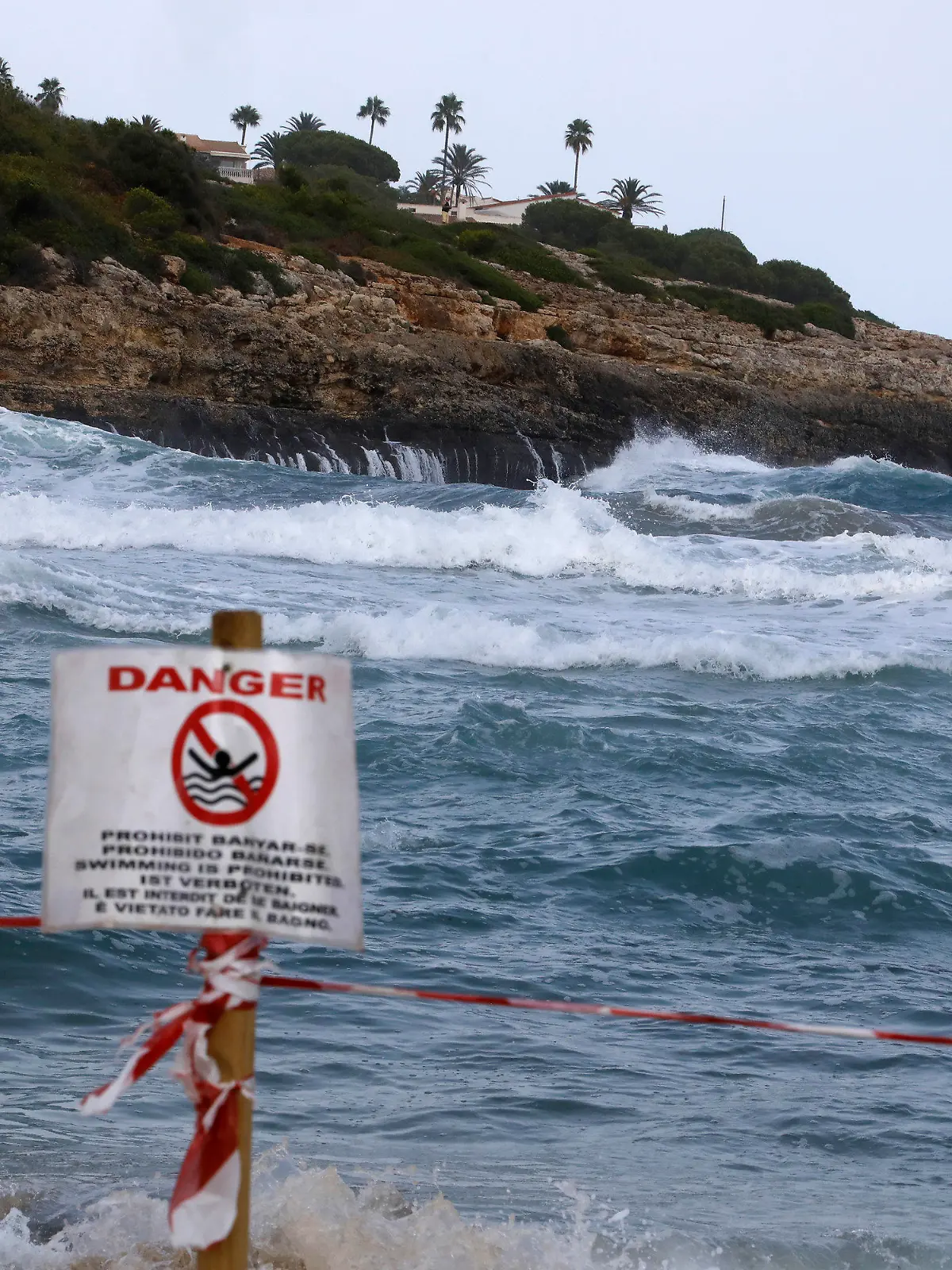 02.09.2021, Spanien, Manacor: Ein Schild verbietet das Schwimmen am Strand von Cala Mendia in Manacor auf Mallorca. Zwei junge Urlauberinnen aus Nordrhein-Westfalen sind hier im Meer vor Mallorca ertrunken. Die beiden Schwestern waren nach ersten Erkenntnissen gegen 2.30 Uhr zusammen mit vier weiteren jungen Touristinnen und einem 30 Jahre alten Urlauber trotz roter Flagge ins Meer gegangen. Foto: Clara Margais/dpa +++ dpa-Bildfunk +++