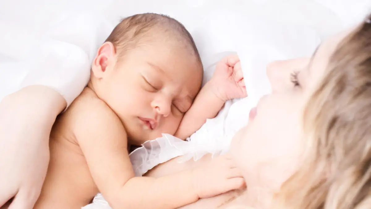 Newborn sleeping child in the hands of mother