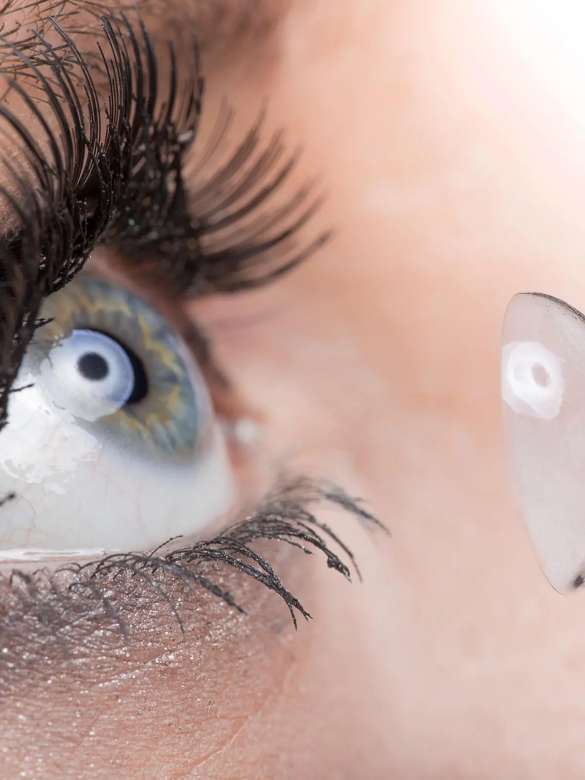 Young woman Inserting a contact lens, close-up