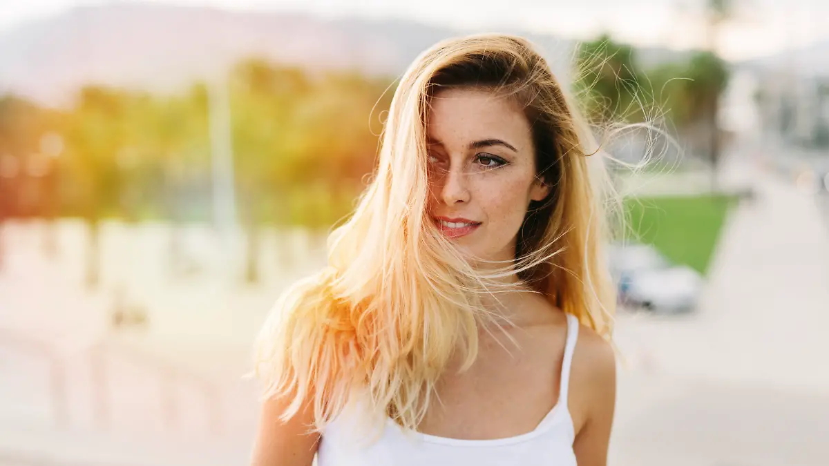 Beautiful woman looking away and with hair blowing in the wind.