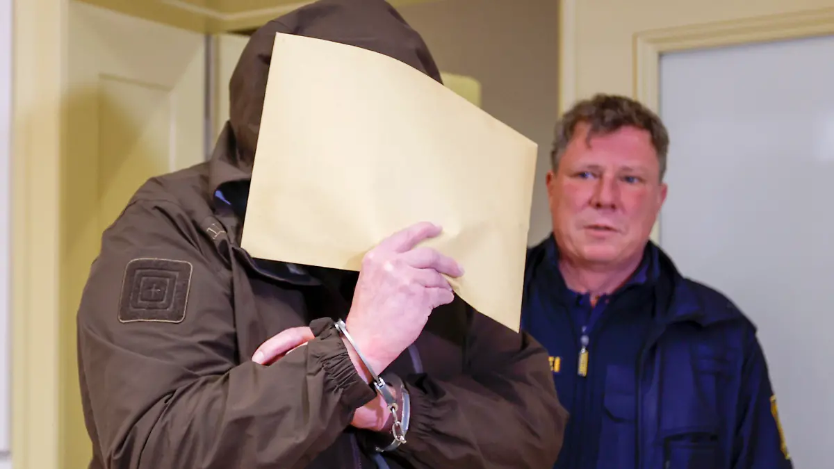 17.01.2023, Bayern, Schweinfurt: Der Angeklagte (l) betritt in Begleitung von Justizbeamten den Sitzungssaal. Der 54-jährige Mann, soll die damals minderjährigen Tochter seiner Partnerin zwischen 2015 und 2016 im Raum Hammelburg (Landkreis Bad Kissingen) sexuell missbraucht haben. Zudem soll er später das Opfer im Internet für sexuelle Dienstleistungen angeboten haben. Die Mutter der jungen Frau ist wegen Beihilfe zum sexuellen Missbrauch und Zwangsprostitution angeklagt. Foto: Heiko Becker/dpa +++ dpa-Bildfunk +++