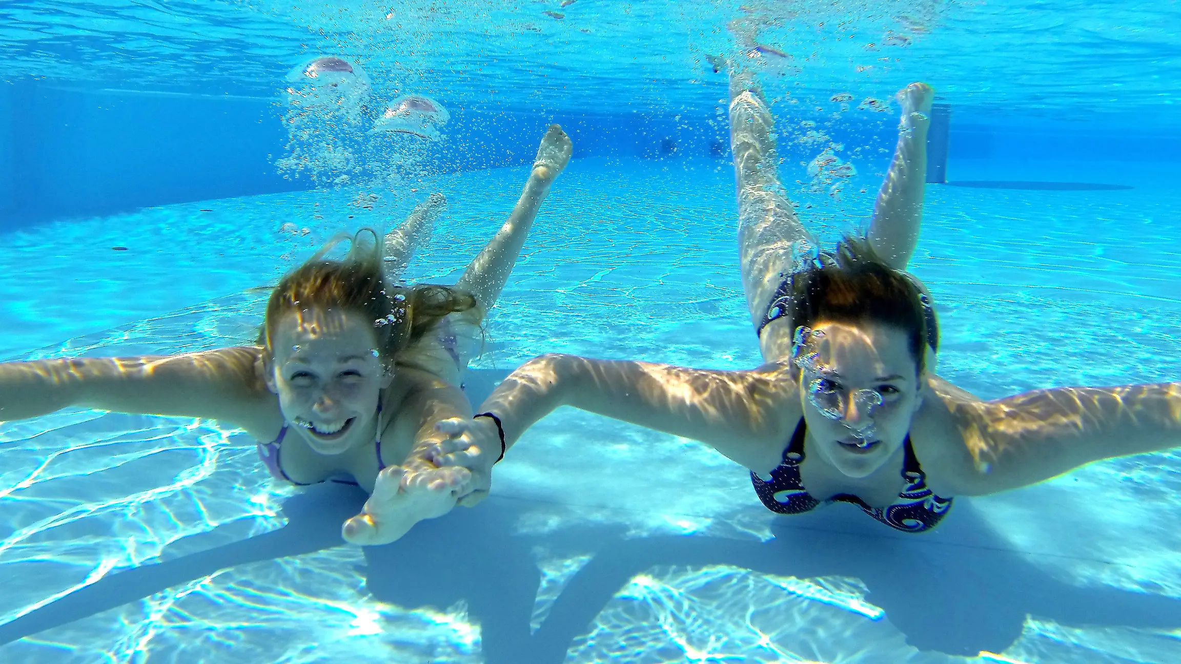Vivian (l) und Malina tauchen am 20.05.2014 im Freibad am Brauweg in Göttingen (Niedersachsen) im Wasser. Foto: Swen Pförtner/dpa +++(c) dpa - Bildfunk+++