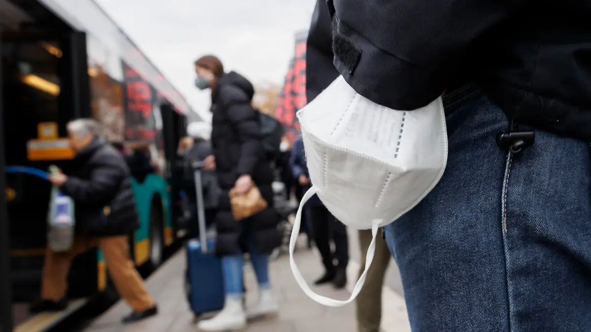 05.12.2022, Baden-Württemberg, Stuttgart: Ein Mann wartet mit einer Maske am Handgelenk auf einen Bus am Stuttgarter Hauptbahnhof. Die digitale Gesundheitsministerkonferenz der Länder berät über die Zukunft der Maskenpflicht. Foto: Julian Rettig/dpa +++ dpa-Bildfunk +++