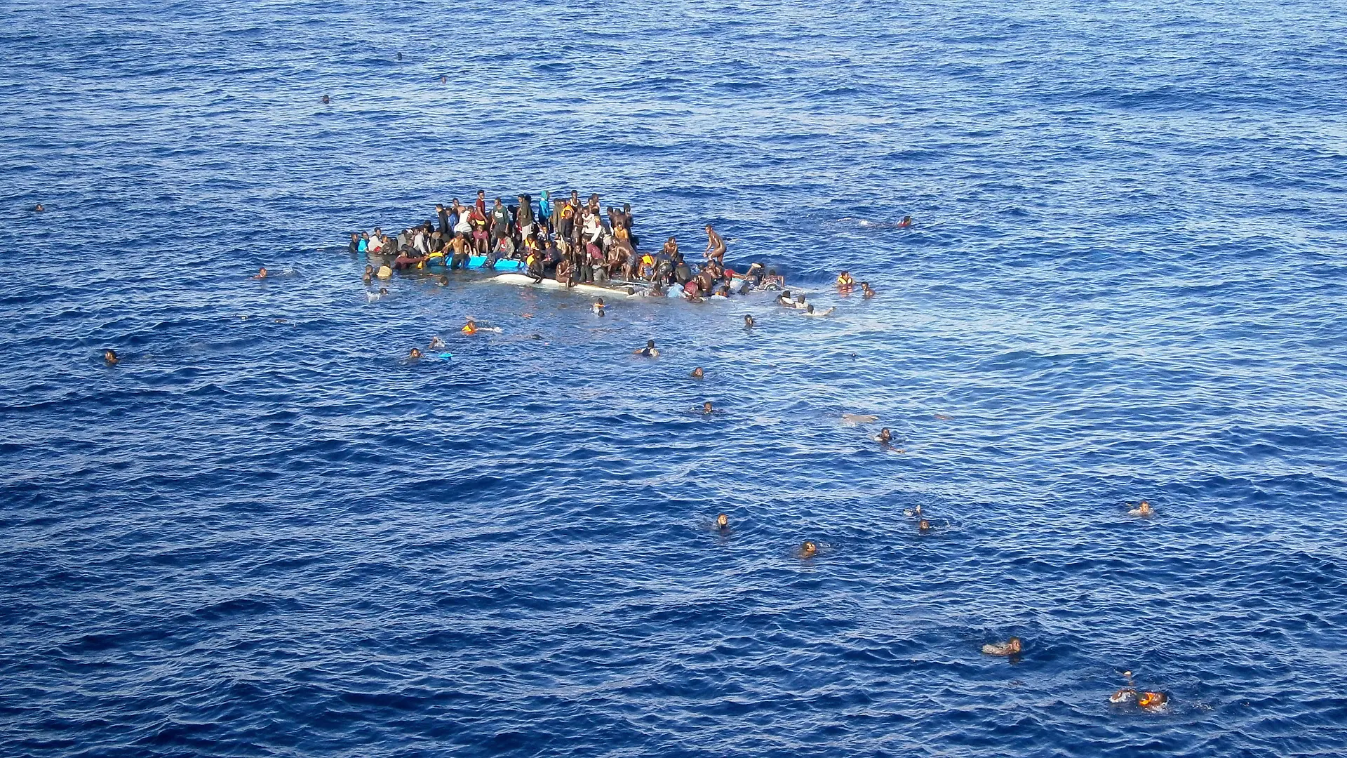 HANDOUT - Die Aufnahme vom 12.04.2015 zeigt Flüchtlinge, die mit ihrem Boot in unmittelbarer Nähe des Frachtschiffes "OOC Jaguar" auf dem Mittelmeer gekentert sind. Die Schiffe der Reederei Opielok Offshore Carriers haben seit Dezember vergangenen Jahres über 1500 Menschen aus dem Mittelmeer gerettet. Foto: Opielok Offshore Carriers/dpa (zu dpa "Mittelmeer-Flüchtlinge bringen auch deutsche Reeder in Notlagen" vom 20.04.2015 - ACHTUNG: Nur zur redaktionellen Verwendung im Zusammenhang mit der Berichterstattung und nur mit Urhebernennung Foto: Opielok Offshore Carriers/dpa) +++(c) dpa - Bildfunk+++