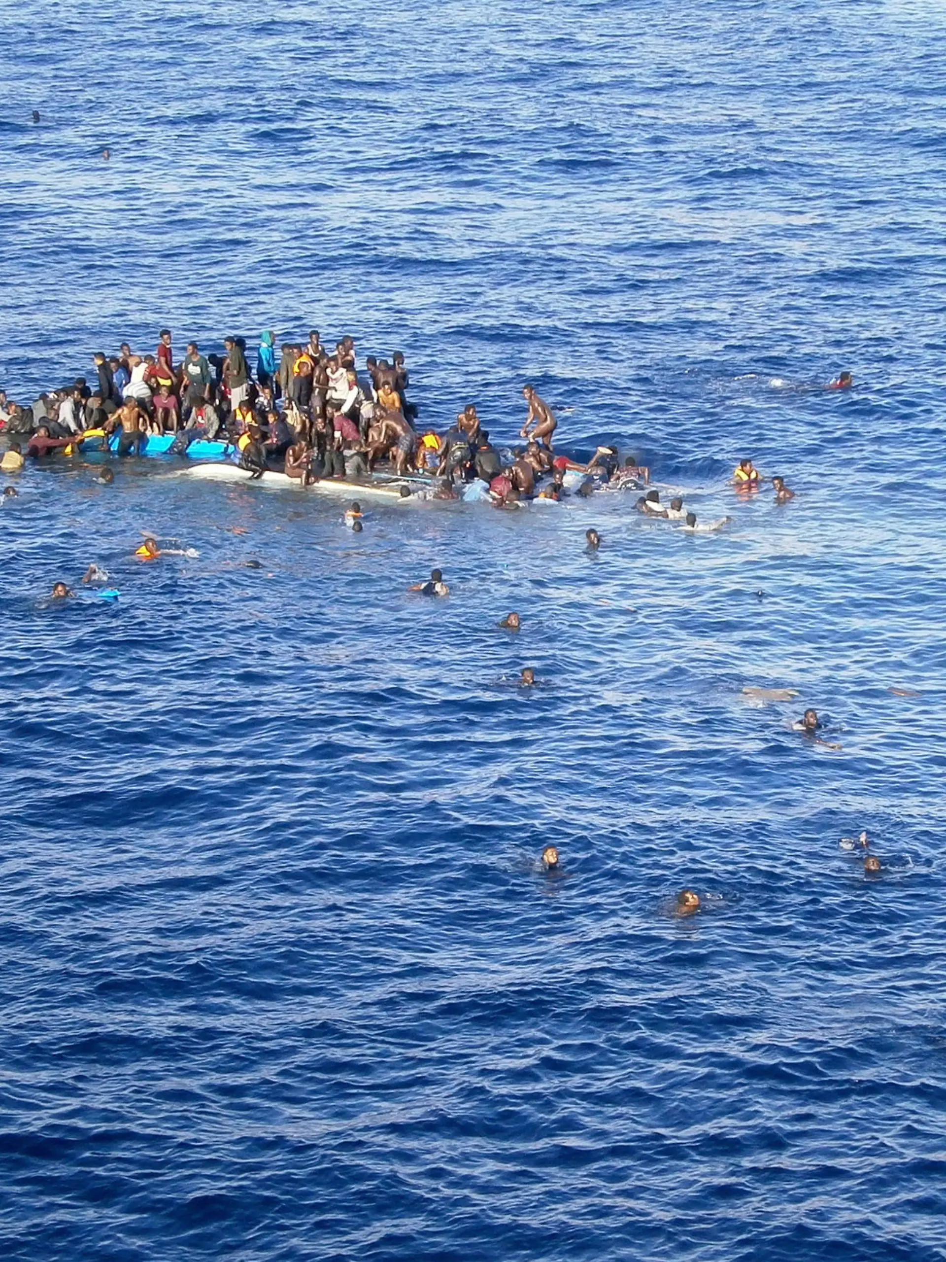 HANDOUT - Die Aufnahme vom 12.04.2015 zeigt Flüchtlinge, die mit ihrem Boot in unmittelbarer Nähe des Frachtschiffes "OOC Jaguar" auf dem Mittelmeer gekentert sind. Die Schiffe der Reederei Opielok Offshore Carriers haben seit Dezember vergangenen Jahres über 1500 Menschen aus dem Mittelmeer gerettet. Foto: Opielok Offshore Carriers/dpa (zu dpa "Mittelmeer-Flüchtlinge bringen auch deutsche Reeder in Notlagen" vom 20.04.2015 - ACHTUNG: Nur zur redaktionellen Verwendung im Zusammenhang mit der Berichterstattung und nur mit Urhebernennung Foto: Opielok Offshore Carriers/dpa) +++(c) dpa - Bildfunk+++