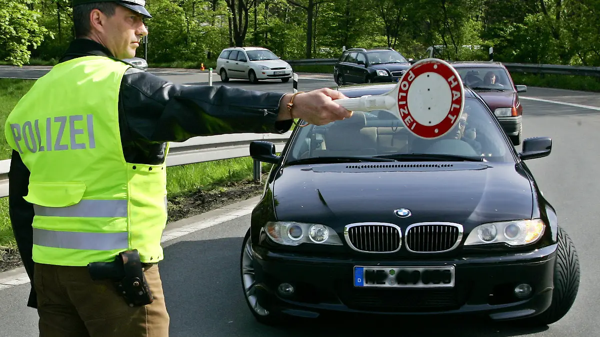 ARCHIV - Mit der Kelle stoppt ein Polizist einen Autofahrer auf der Autobahn 46 Richtung Neuss (Archivfoto vom 28.04.2005) Verkehrsrowdys sollen künftig stärker zur Kasse gebeten werden. «Wer als Rowdy vorsätzlich rast oder drängelt, soll künftig bis zu 2000 Euro zahlen», sagte Bundesverkehrsminister Wolfgang Tiefensee der «Bild»-Zeitung (16.05.2006). Foto: Roland Weihrauch +++(c) dpa - Bildfunk+++