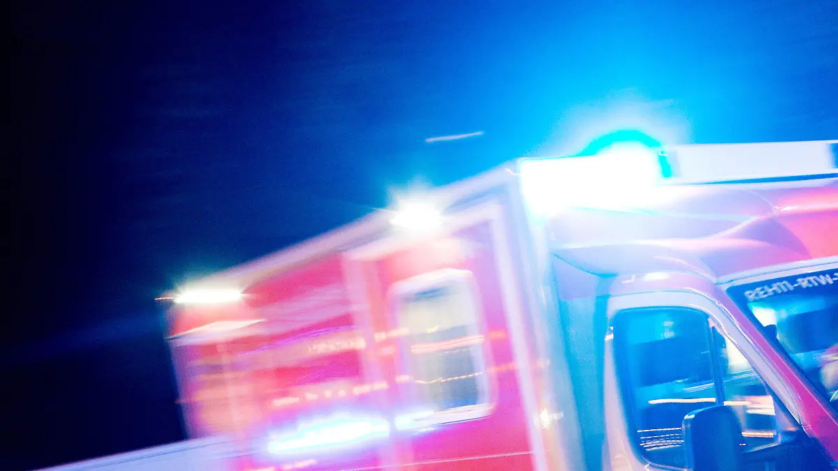 ARCHIV - ILLUSTRATION - Ein Rettungswagen der Feuerwehr fährt am 17.10.2015 in Recklinghausen (Nordrhein-Westfalen) mit Blaulicht durch eine Straße (Aufnahme mit langer Belichtungszeit).  (zu dpa:"Schneller als der Rettungsdienst? NRW-Kreise nutzen Ersthelfer-App") Foto: Marcel Kusch/dpa +++(c) dpa - Bildfunk+++