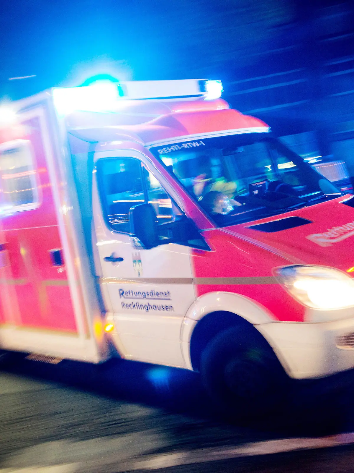 ARCHIV - ILLUSTRATION - Ein Rettungswagen der Feuerwehr fährt am 17.10.2015 in Recklinghausen (Nordrhein-Westfalen) mit Blaulicht durch eine Straße (Aufnahme mit langer Belichtungszeit).  (zu dpa:"Schneller als der Rettungsdienst? NRW-Kreise nutzen Ersthelfer-App") Foto: Marcel Kusch/dpa +++(c) dpa - Bildfunk+++