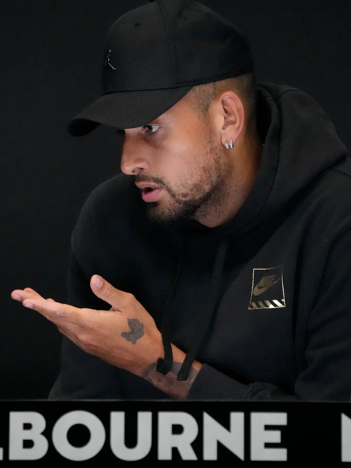 16.01.2023, Australien, Melbourne: Der Australier Nick Kyrgios reagiert, als er auf einer Pressekonferenz seinen Rücktritt von den Australian Open wegen einer Knieverletzung bekannt gibt. Foto: Mark Baker/AP/dpa +++ dpa-Bildfunk +++