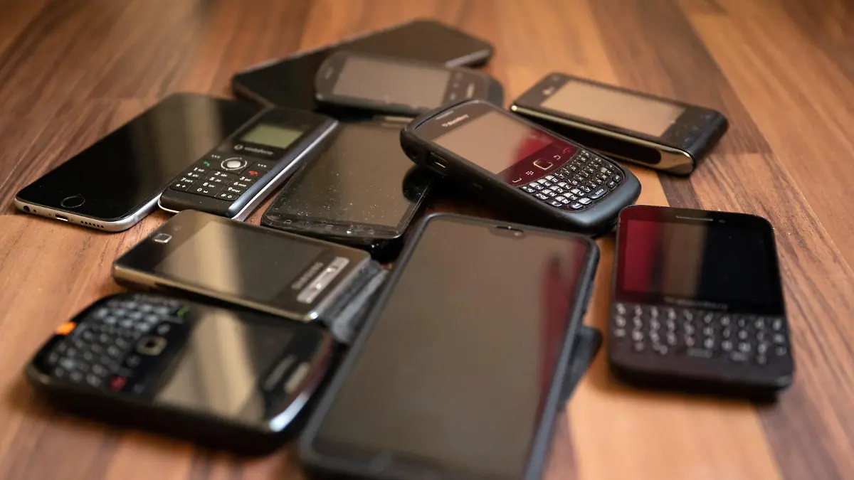 Ungenutzte Handys liegen auf dem Boden. In Deutschland nutzen knapp 70 Millionen Menschen ein Smartphone - und viele von ihnen haben noch ein oder mehrere alte Geräte ungenutzt in der Schublade liegen.