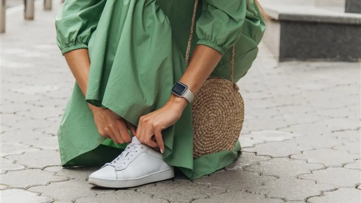 Frau trägt weiße Sneaker.