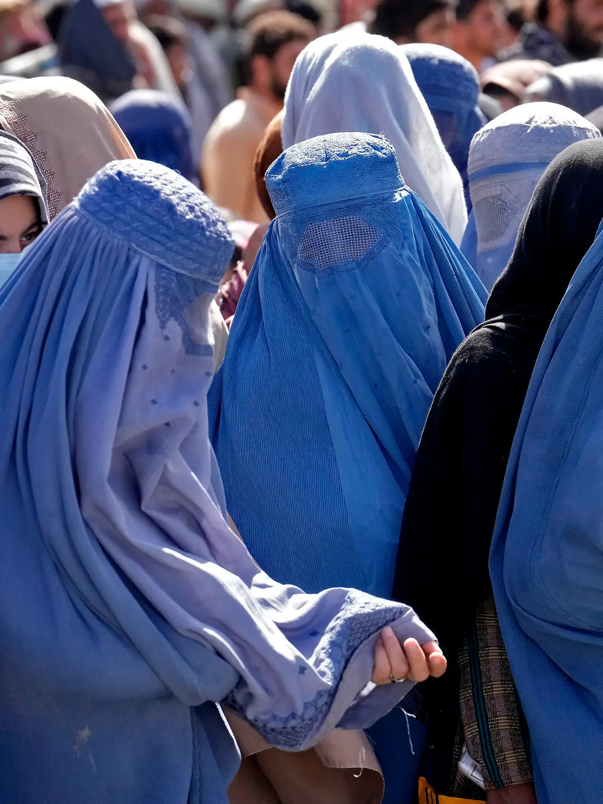 ARCHIV - 15.08.2022, Afghanistan, Kabul: Frauen in Burkas warten auf Lebensmittelrationen, die von einer humanitären Hilfsorganisation aus Saudi-Arabien verteilt werden. In Afghanistan befürchten Medienberichten zufolge Frauen weitere Einschränkungen durch die im Land regierenden islamistischen Taliban. Foto: Ebrahim Noroozi/AP/dpa +++ dpa-Bildfunk +++