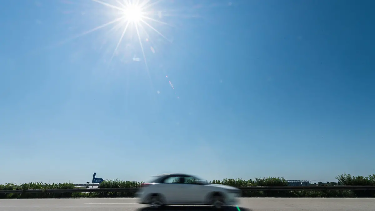 Ein Auto fährt am 01.07.2015 auf der Autobahn A 92 nahe Dingolfing (Bayern) im Gegenlicht der Sonne. Laut einem Sprecher der Autobahndirektion Südbayern seien bislang noch keine Hitzeschäden auf den Autobahnen aufgetreten. Das kann sich jedoch in den kommenden Tagen ändern. Der Deutsche Wetterdienst erwartet am Wochenende Temperaturen von bis zu 38 Grad im Freistaat. Foto: Armin Weigel/dpa +++(c) dpa - Bildfunk+++