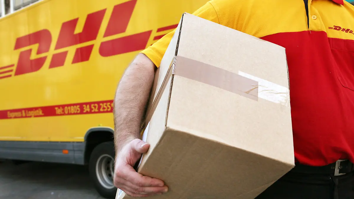 ARCHIV - Ein Mitarbeiter des Paketdienstleisters DHL der Deutschen Post trägt am 12.11.2008 in Köln ein Paket zum Kunden. Der Paketboom und Expressbriefe rund um die Welt haben der Deutschen Post im Sommer im Kampf gegen den starken Euro geholfen. Zwar ging der Umsatz im dritten Quartal wegen ungünstiger Wechselkurse um 2,5 Prozent auf 13,5 Milliarden Euro zurück, wie der Dax-Konzern am Dienstag in Frankfurt mitteilte. Das operative Ergebnis (EBIT) legte hingegen auch dank des erhöhten Briefportos um sieben Prozent auf 646 Millionen Euro zu. Der Überschuss kletterte um sechs Prozent auf 399 Millionen Euro. Foto: Oliver Berg/dpa +++(c) dpa - Bildfunk+++