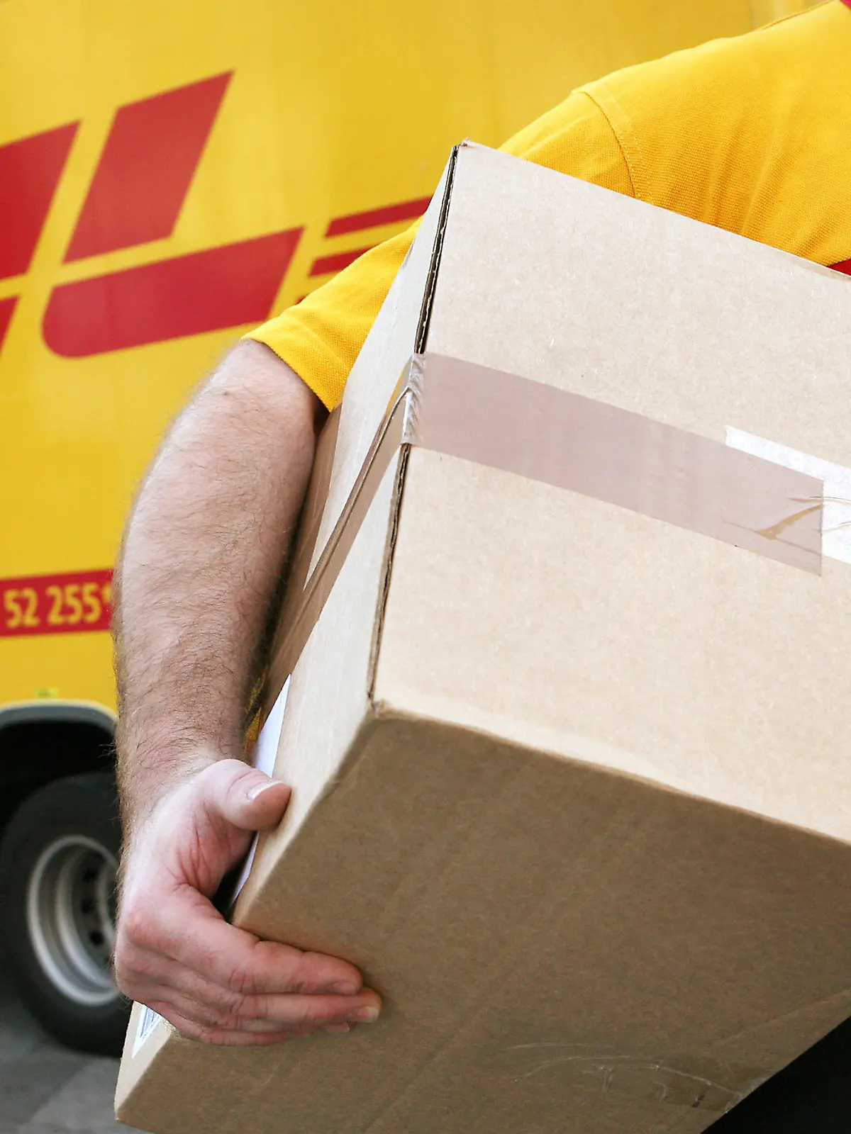 ARCHIV - Ein Mitarbeiter des Paketdienstleisters DHL der Deutschen Post trägt am 12.11.2008 in Köln ein Paket zum Kunden. Der Paketboom und Expressbriefe rund um die Welt haben der Deutschen Post im Sommer im Kampf gegen den starken Euro geholfen. Zwar ging der Umsatz im dritten Quartal wegen ungünstiger Wechselkurse um 2,5 Prozent auf 13,5 Milliarden Euro zurück, wie der Dax-Konzern am Dienstag in Frankfurt mitteilte. Das operative Ergebnis (EBIT) legte hingegen auch dank des erhöhten Briefportos um sieben Prozent auf 646 Millionen Euro zu. Der Überschuss kletterte um sechs Prozent auf 399 Millionen Euro. Foto: Oliver Berg/dpa +++(c) dpa - Bildfunk+++