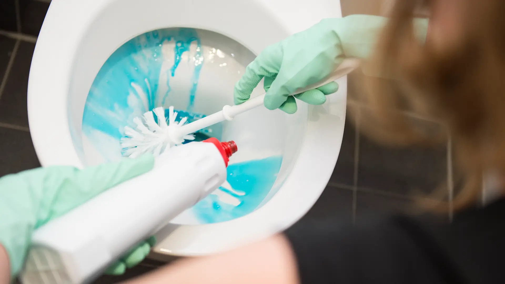 Frau putzt Toilette