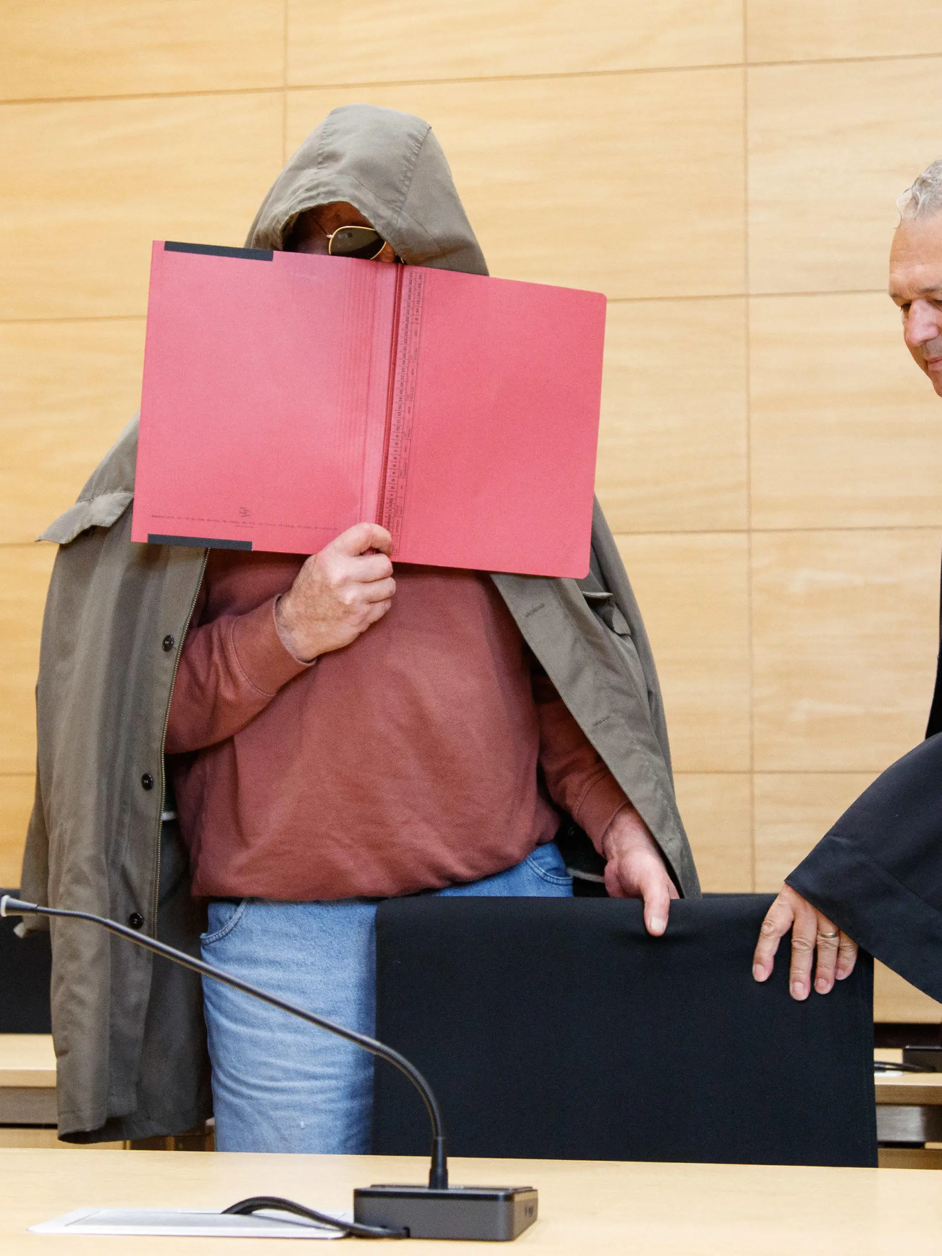09.08.2023, Nordrhein-Westfalen, Bielefeld: Georg Schulze (r), der Verteidiger des Angeklagten, steht neben seinem Mandanten. Damit beginnt ein Prozess um Totschlag unter Nachbarn. Die Staatsanwaltschaft wirft einem 61-Jährigen aus Gütersloh vor, seinen Nachbarn nach jahrelangen Streitigkeiten am 9. Februar 2023 getötet zu haben. Der Angeklagte soll zuerst die Haustür seines Nachbarn mit einer Spaltaxt beschädigt und dann geöffnet haben. Es folgte ein Streit mit Worten und eine körperliche Auseinandersetzung. Dabei verletzte der Angreifer den Bewohner mit einem mitgebrachten Messer. 15 Mal traf er den 59-Jährigen, der an den Schnittverletzungen später im Krankenhaus starb. Foto: Friso Gentsch/dpa +++ dpa-Bildfunk +++