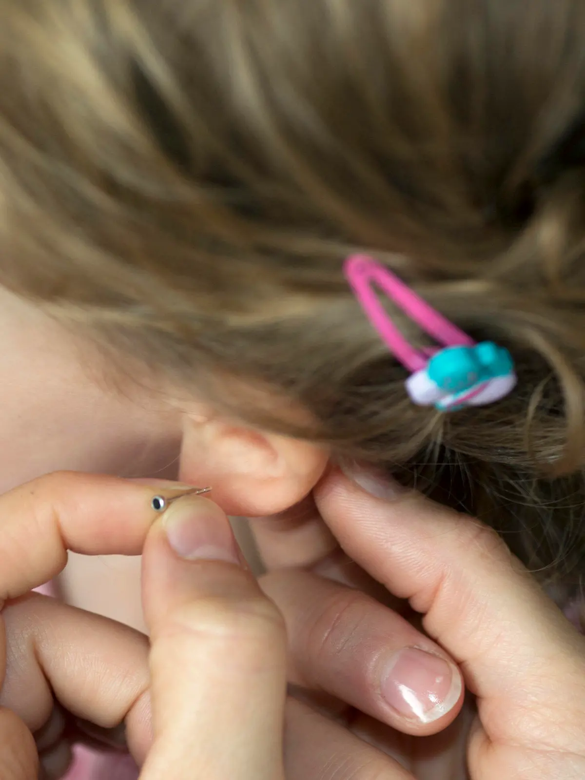 ILLUSTRATION - Eine Mutter hält am Donnerstag (30.08.2012) in Berlin einen Ohrstecker an das Ohrläppchen ihrer zweijährigen Tochter. Nach dem Verbot der religiösen Beschneidung kommt nun die Frage vor Gericht, ob das Stechen von Ohrlöchern bei kleinen Kindern eine ähnliche Körperverletzung darstellt. Am Freitag (31.08.2012) verhandelt ein Berliner Amtsgericht in einem Zivilprozess über einen derartigen Fall. Foto: Florian Schuh dpa/lbn (zu dpa 0295 vom 30.08.2012)  +++(c) dpa - Bildfunk+++