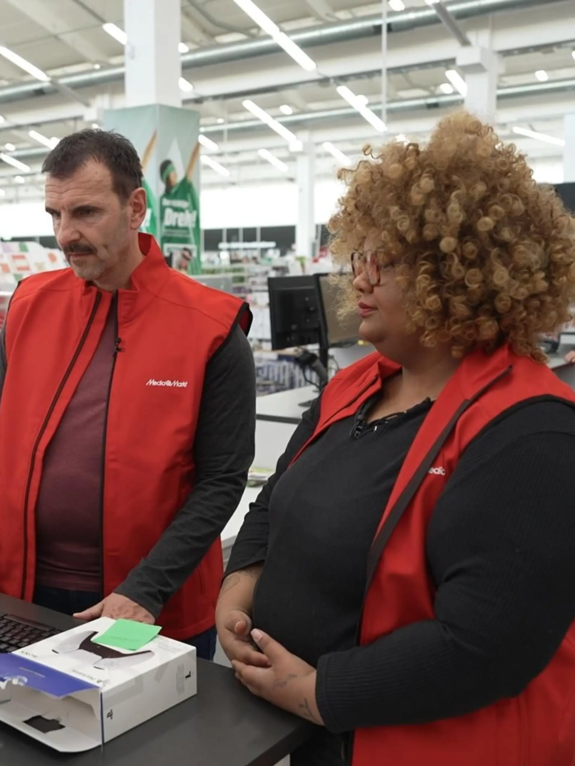 Mario Pieper alias Marco und Adesua am Service Counter in Augsburg.
+++ Die Verwendung des sendungsbezogenen Materials ist nur mit dem Hinweis und Verlinkung auf RTL+ gestattet. +++