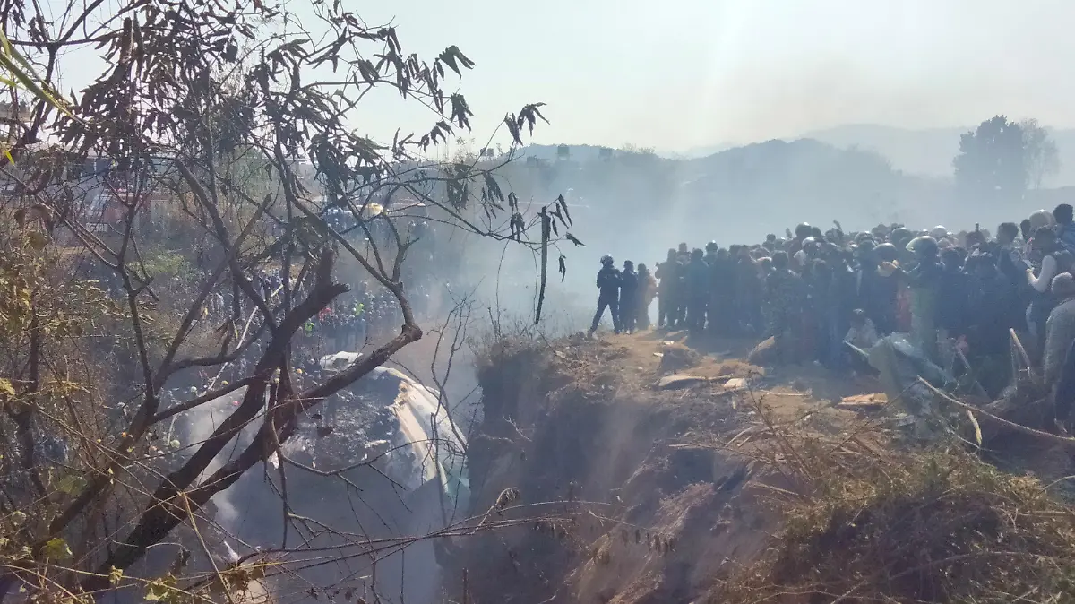 Crowds gather at the crash site of an aircraft carrying 72 people in Pokhara in western Nepal January 15, 2023. Sagar Raj Timilsina/Handout via REUTERS THIS IMAGE HAS BEEN SUPPLIED BY A THIRD PARTY. MANDATORY CREDIT. NO RESALES. NO ARCHIVES.