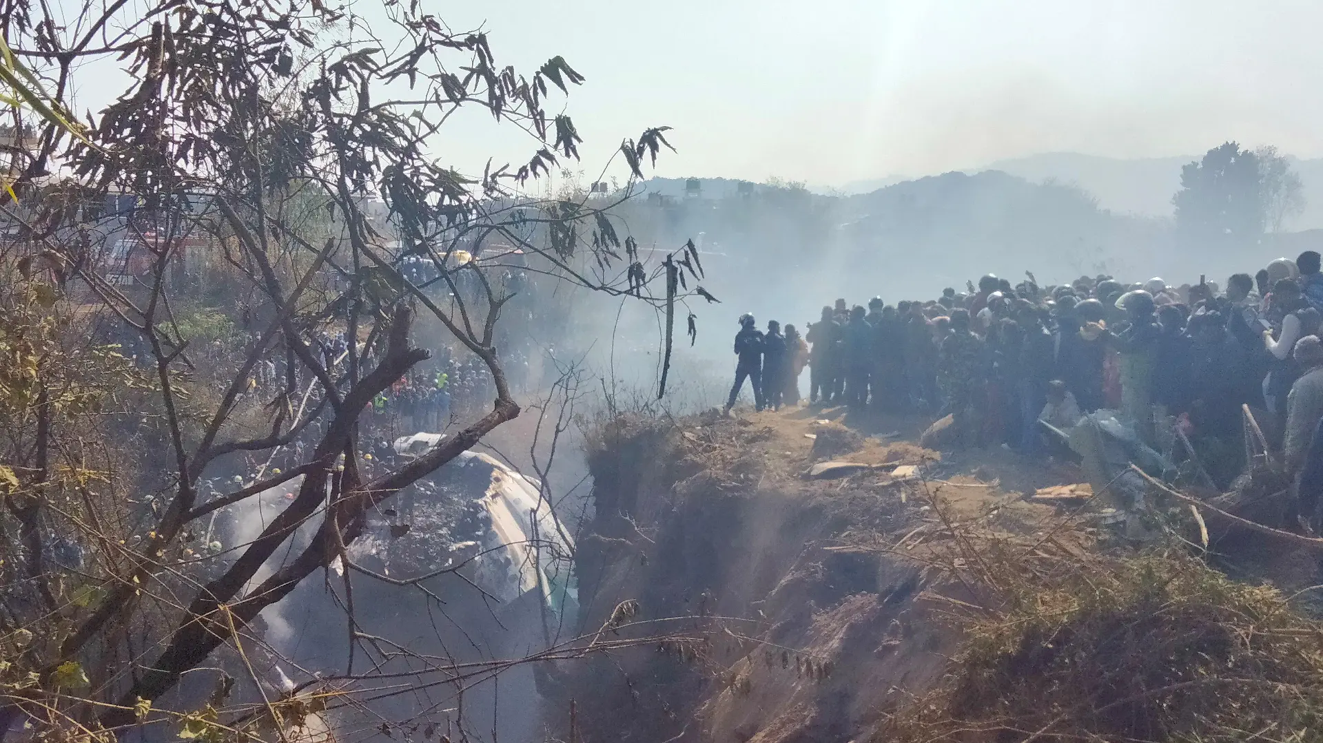Crowds gather at the crash site of an aircraft carrying 72 people in Pokhara in western Nepal January 15, 2023. Sagar Raj Timilsina/Handout via REUTERS    THIS IMAGE HAS BEEN SUPPLIED BY A THIRD PARTY. MANDATORY CREDIT. NO RESALES. NO ARCHIVES.