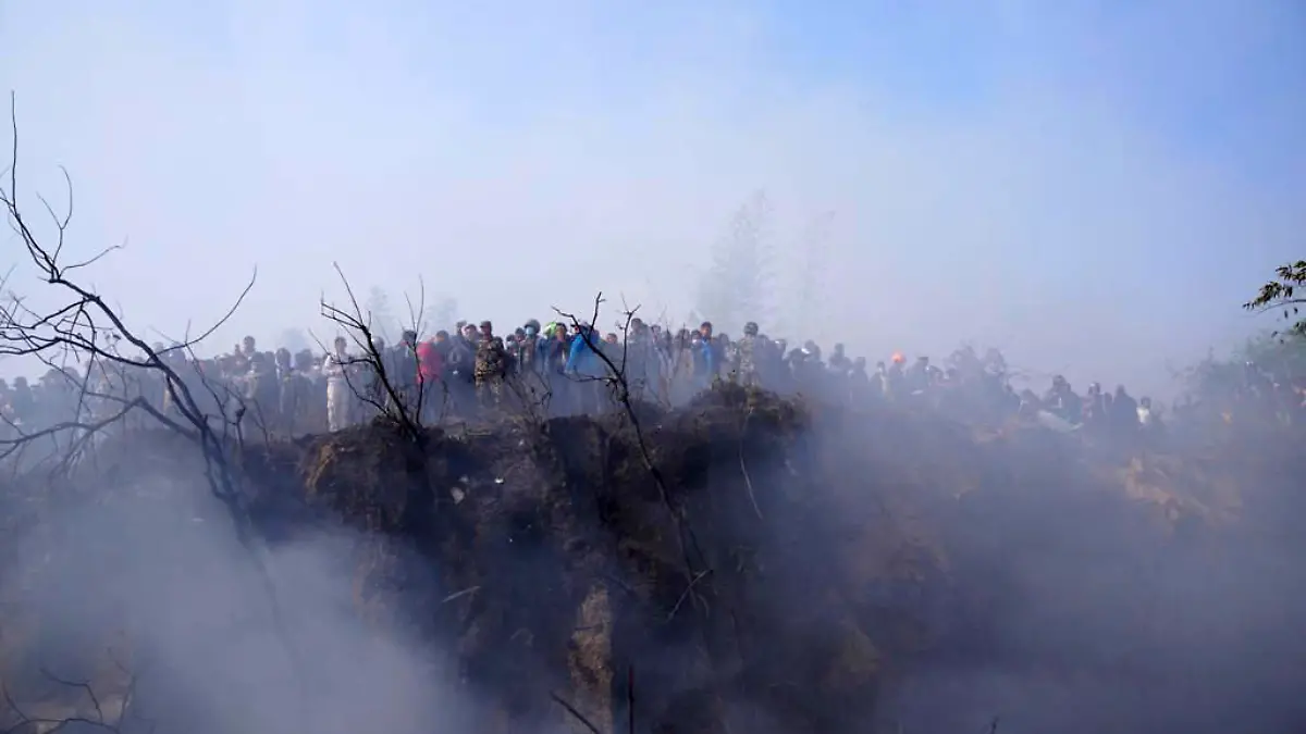 15.01.2023, Nepal, Pokhara: Einheimische betrachten das Wrack eines abgestürzten Passagierflugzeugs. Das Passagierflugzeug mit 72 Menschen an Bord ist in der Nähe des internationalen Flughafens Pokhara in Nepal abgestürzt, berichtet die Tageszeitung Kathmandu Post. An Bord des Flugzeugs befanden sich 68 Passagiere und vier Besatzungsmitglieder. Foto: Yunish Gurung/AP/dpa +++ dpa-Bildfunk +++