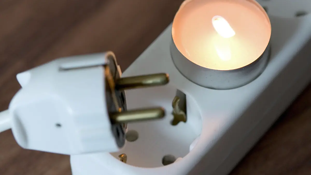 Ein Teelicht steckt am Montag (14.01.2008) in Osnabrück in einer Steckdose, darunter ein Stecker. Illustration zum Thema Energie, Strom, Elektrizität, Betriebs- und Nebenkosten. Foto: Friso Gentsch dpa/lni +++(c) dpa - Report+++