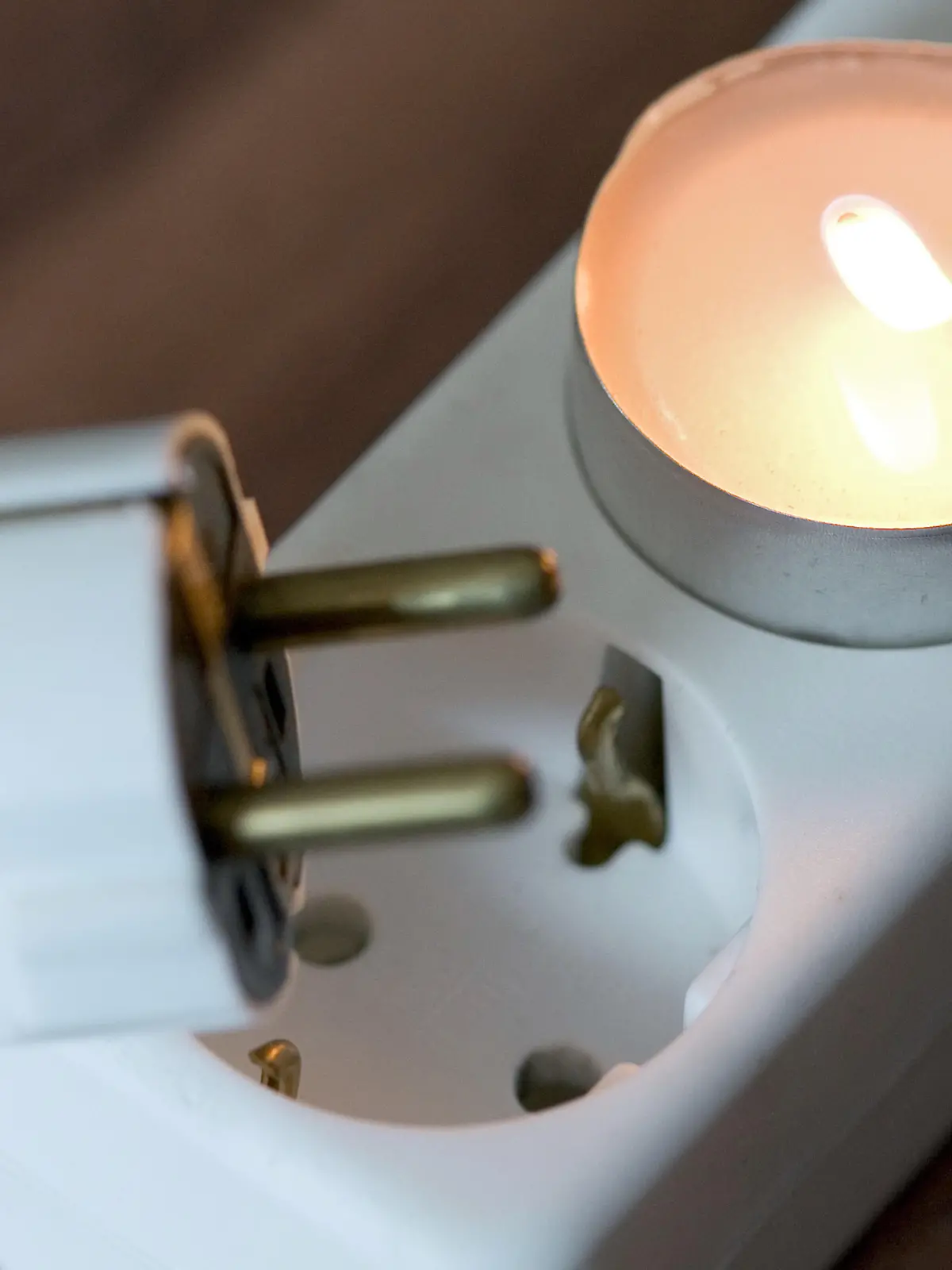 Ein Teelicht steckt am Montag (14.01.2008) in Osnabrück in einer Steckdose, darunter ein Stecker. Illustration zum Thema Energie, Strom, Elektrizität, Betriebs- und Nebenkosten. Foto: Friso Gentsch dpa/lni +++(c) dpa - Report+++