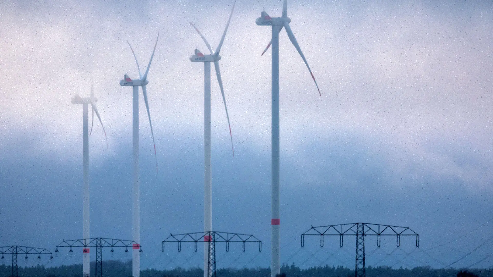 08.12.2022, Mecklenburg-Vorpommern, Parchim: Tief hängende Wolken ziehen über Anlagen in einem Windpark. Mit Nebel, Temperaturen um die null Grad und Schneeregen zeigt sich das Winterwetter in Norddeutschland von seiner eher unfreundlichen Seite. Foto: Jens Büttner/dpa +++ dpa-Bildfunk +++