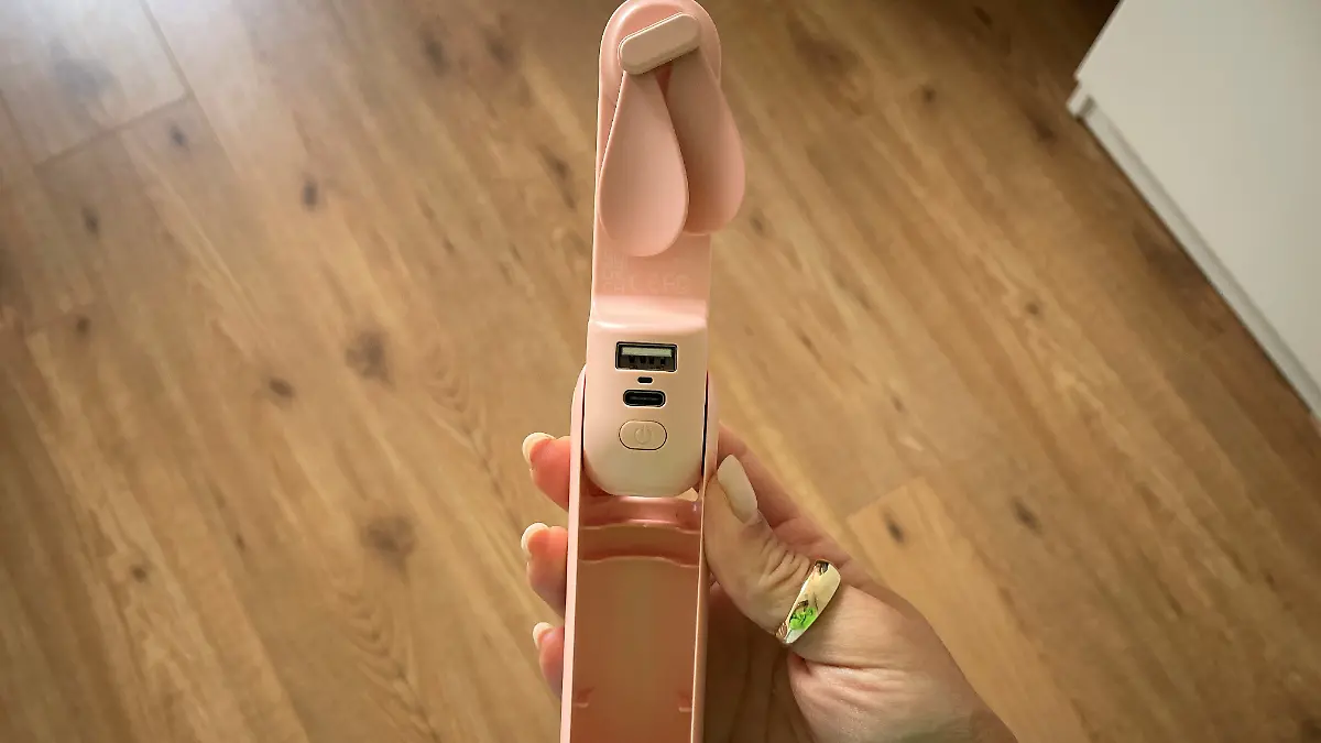 Reproterin hält rosanen Ventilator in der Hand. 