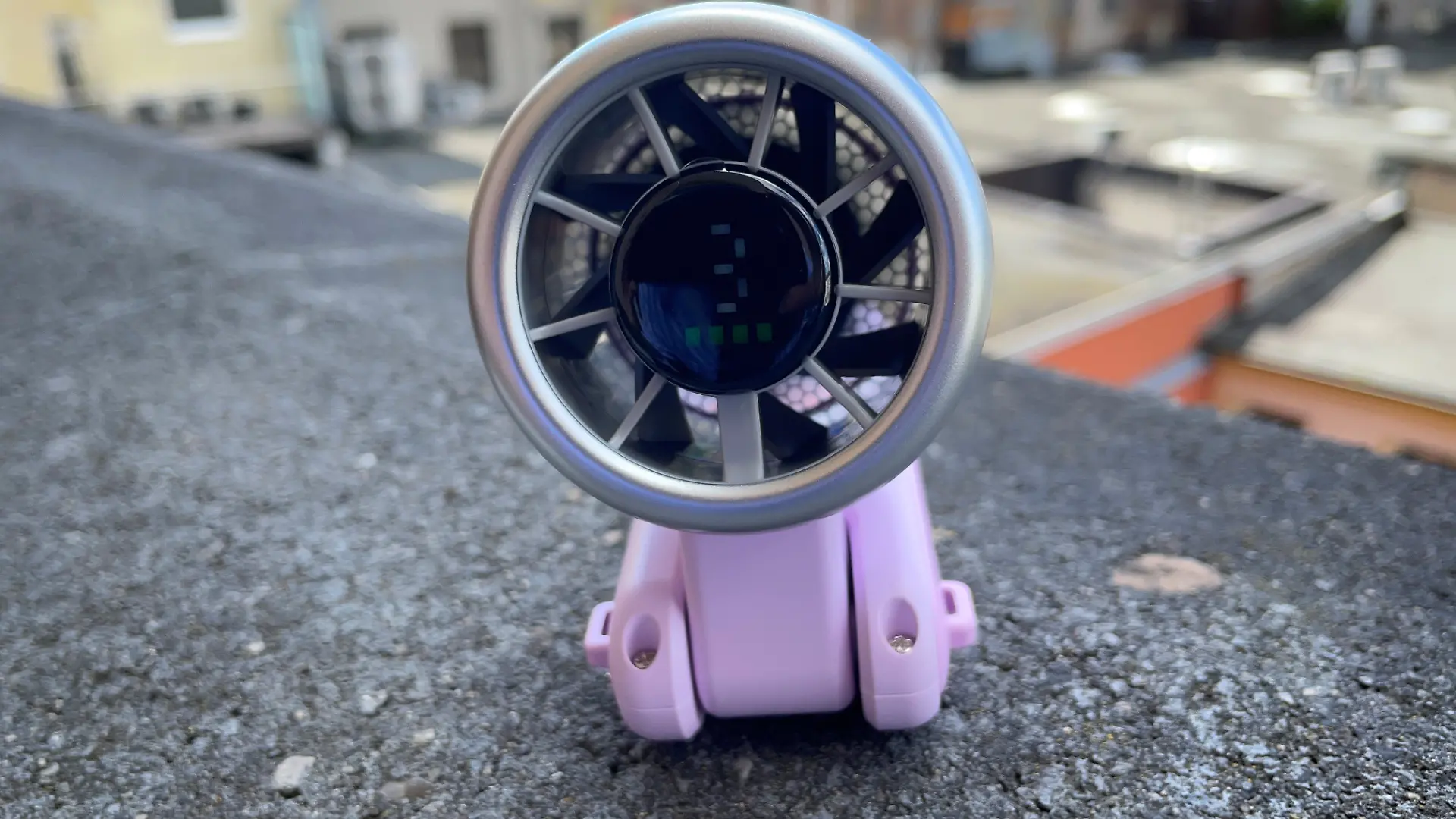 Handventilator ist eingeklappt und steht auf einer Mauer. 