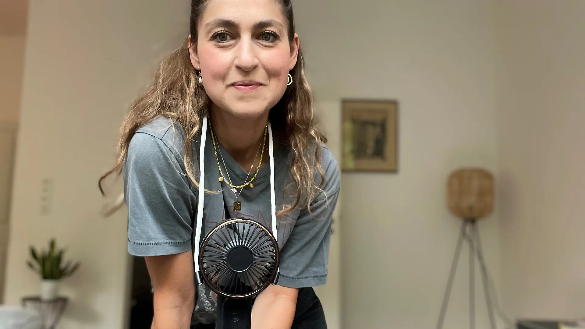 Reporterin trägt Ventilator um den Hals. 