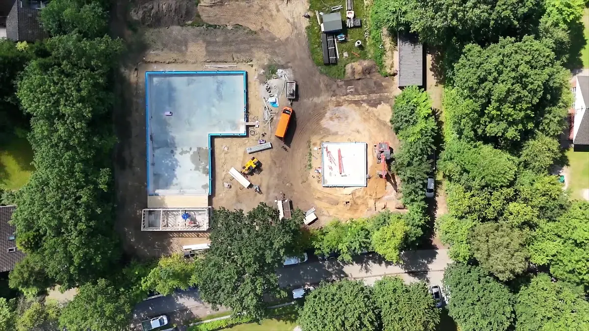 Ein Schwimmbad im Rohbau wird mit einer Drohne von oben fotografiert.
