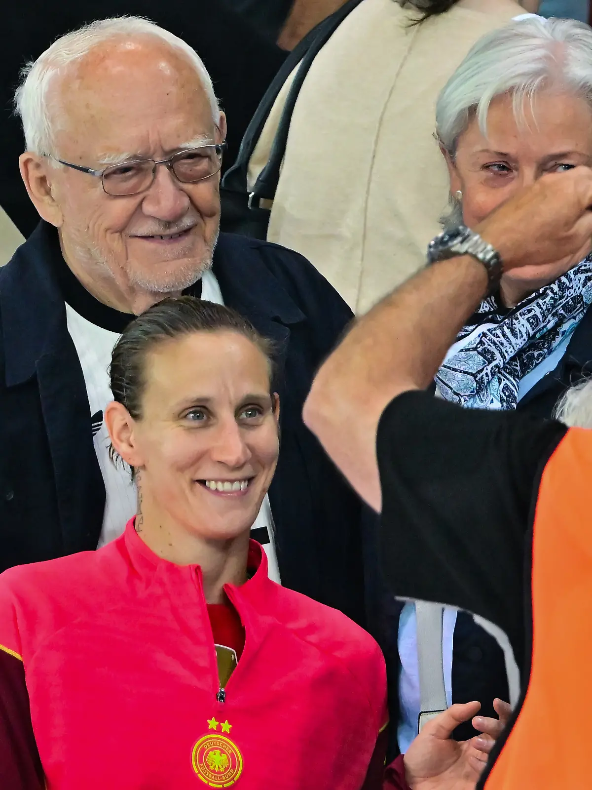 Ein Stewart macht nach dem EM-Halbfinale zwischen Deutschland und Spanien ein Foto von Deutschlands Torhüterin Ann-Katrin Berger und ihrem Großvater Herbert (l).
