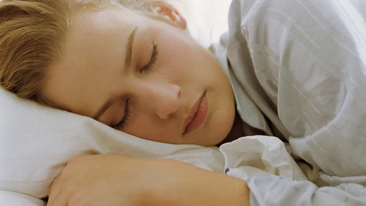 Eine Frau liegt im Bett und schläft.