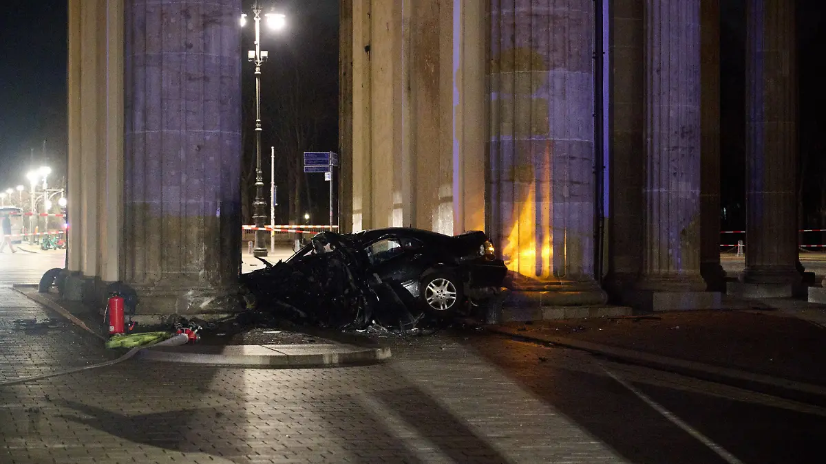 16.01.2023, Berlin: Ein zerstörter PKW liegt zwischen zwei Säulen des Brandenburger Tors. Ein Auto ist gegen eine Säule des Brandenburger Tors in Berlin gefahren. In dem Wagen hätten Feuerwehrleute einen toten Mann gefunden, sagte ein Polizeisprecher am frühen Montagmorgen. Foto: Annette Riedl/dpa +++ dpa-Bildfunk +++