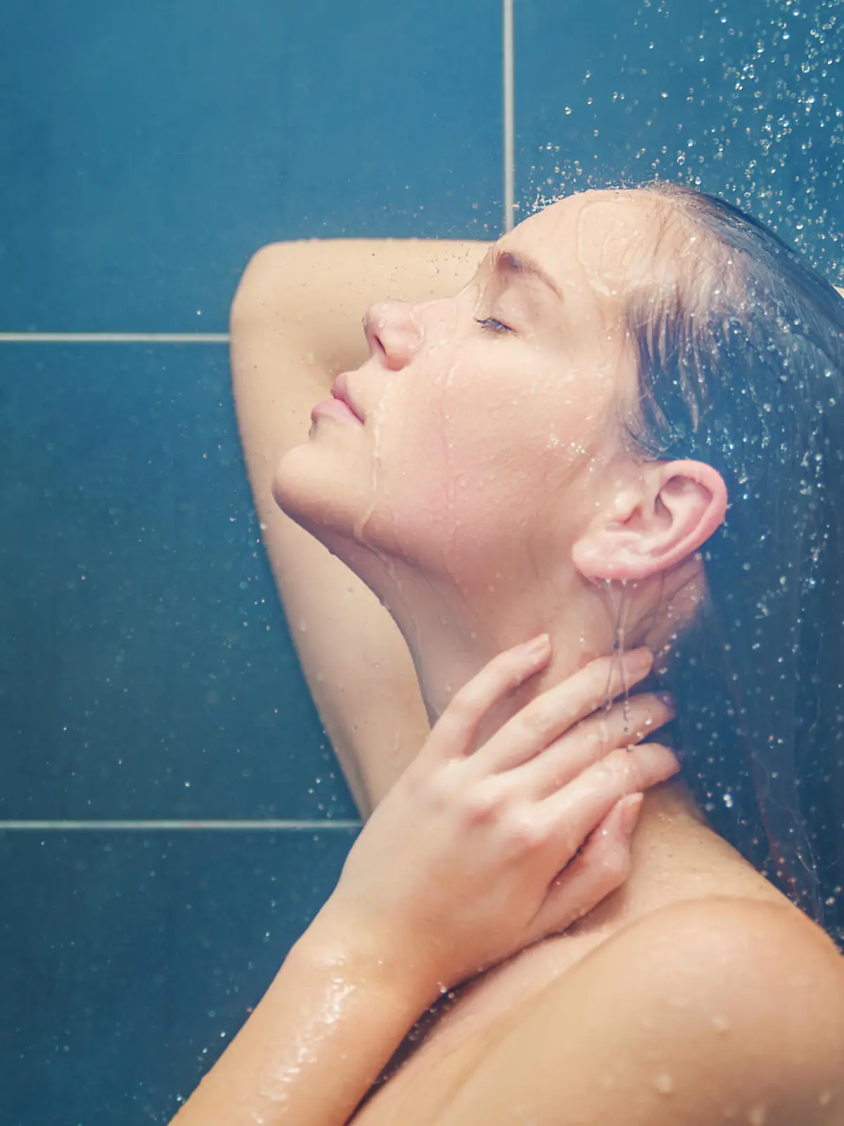 Young beauty enjoying under shower