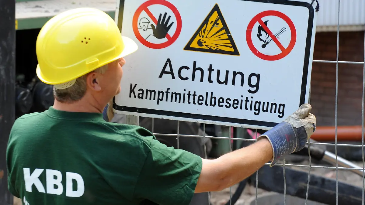 Ein Mitarbeiter des Kampfmittelbeseitigungsdienstes befestigt am Sonntag (14.06.2009) in Hannover ein Warnschild an einer der vier Bombenfundstellen. Für eine der größten Bombenentschärfungen der Nachkriegszeit müssen in Hannover rund 18 000 Menschen ihre Wohnungen verlassen. Insgesamt sollen vier Blindgänger aus dem Zweiten Weltkrieg entschärft werden, die Experten des Kampfmittelbeseitigungsdienstes bei der Auswertung von Luftbildern entdeckt hatten. Foto: Jochen Lübke dpa/lni +++(c) dpa - Bildfunk+++
