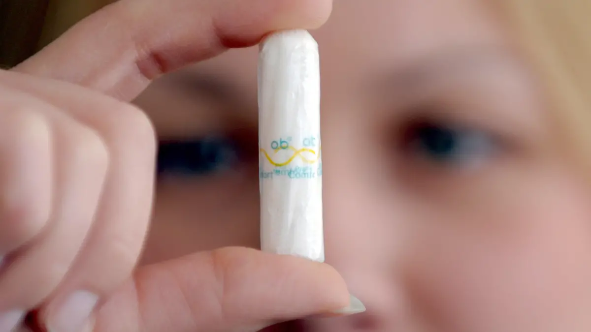 Eine junge Frau hält am Mittwoch (31.03.2010) in Düsseldorf ein Tampon in der Hand. Schafswolle, Blätter, Gräser oder Stoffreste: Mit vielem haben Frauen im gebärfähigen Alter experimentiert, bevor der amerikanische Arzt Earle Cleveland Haas 1931 das Patent für den Tampon beantragte. Der längliche Pfropf aus gepresster Watte war die lange ersehnte Lösung für ein Jahrtausende altes Problem. Im März 1950 - vor 60 Jahren - wurden auch in Deutschland die ersten Tampons verkauft: eine Zehner-Packung für 95 Pfennige. Foto: Federico Gambarini dpa/lnw (zu dpa-KORR:" Wuppertaler Watte - Vor 60 Jahren kam der Tampon nach Deutschland" vom 31.03.2010) +++(c) dpa - Bildfunk+++