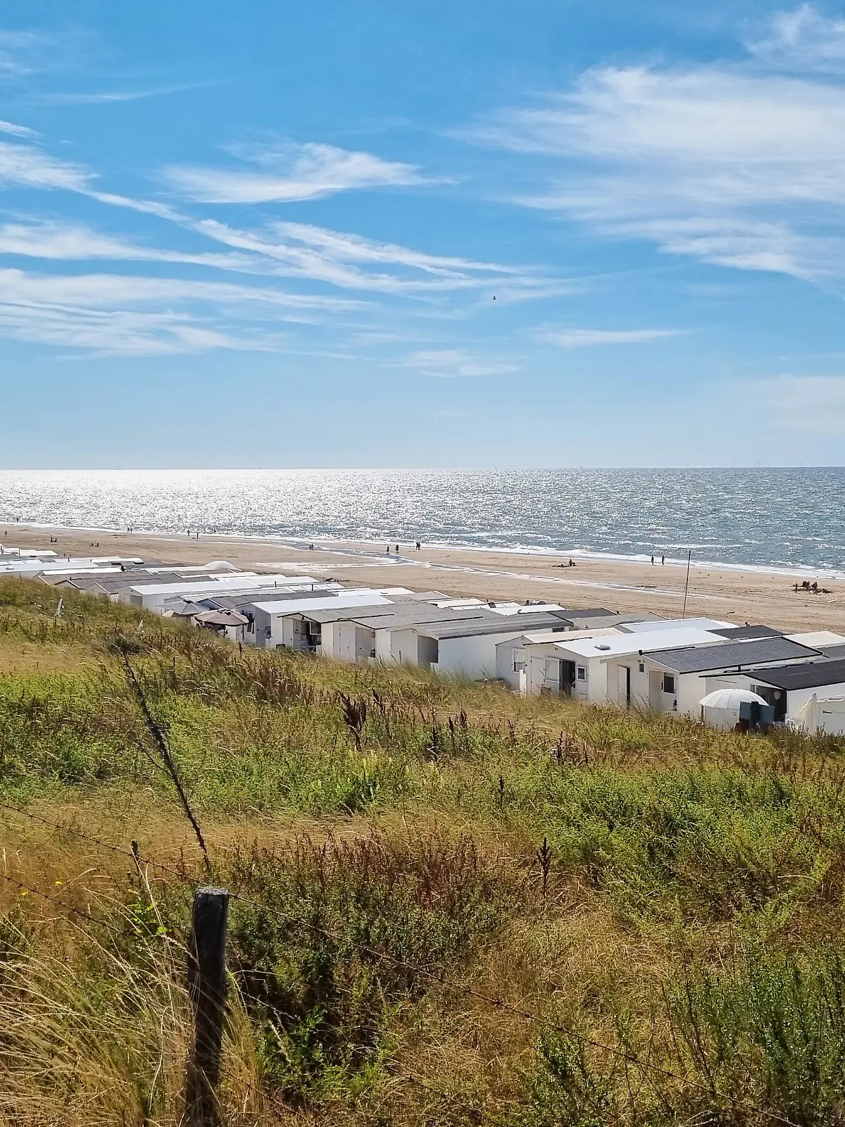 Blick von den Dünen am Strand der Nordseestadt an einem sonnigen Sommerwochenende.