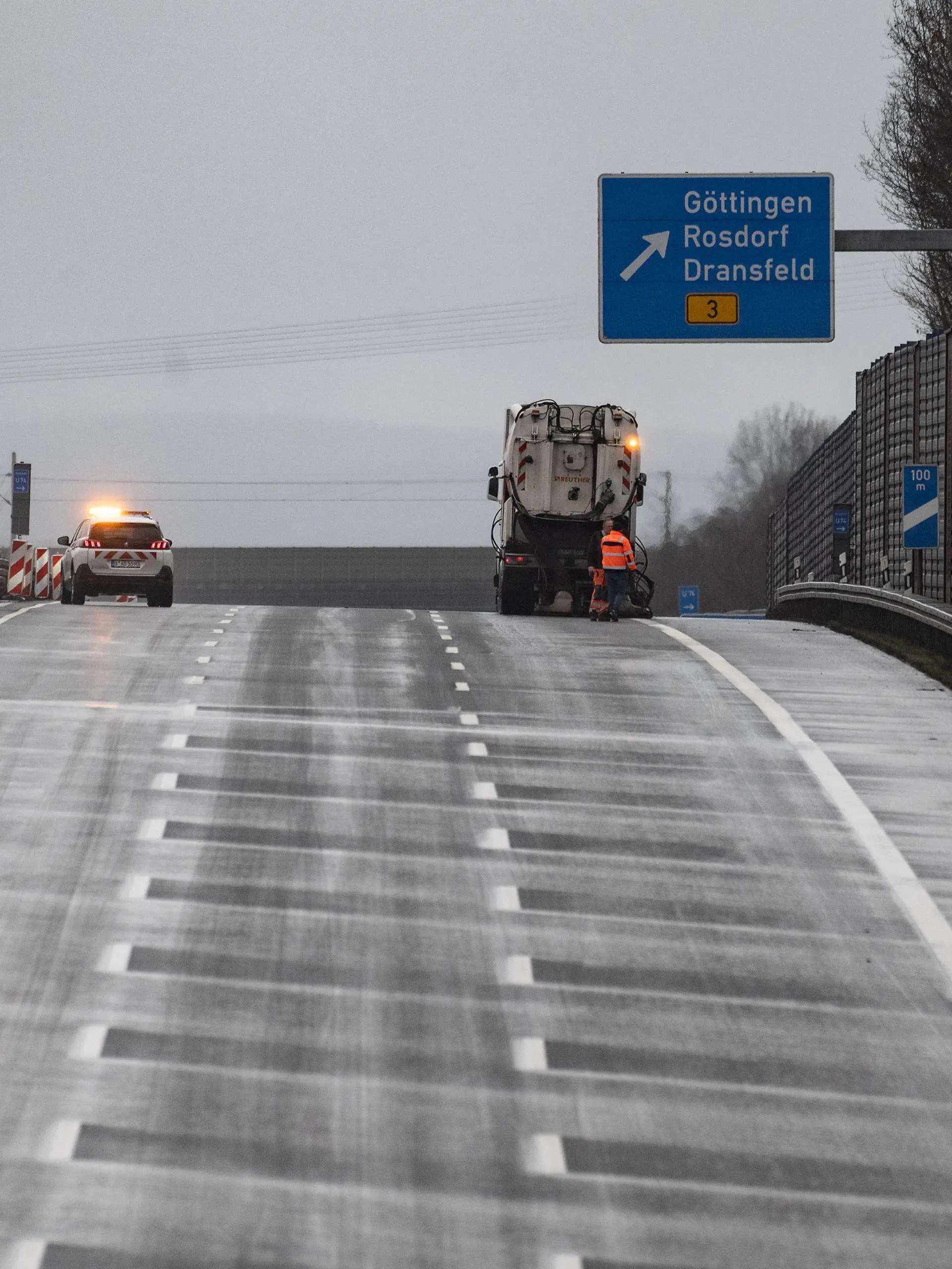 11.01.2023, Niedersachsen, Göttingen: Ein Reinigungsfahrzeug ist auf der Autobahn 7 auf der Strecke im Einsatz.  Die Autobahn 7 in Südniedersachsen bleibt in Richtung Kassel auf rund 60 Kilometern gesperrt. Am Sonntagabend war aus einem Fahrzeug eine weiße, pulvrige Substanz entwichen, vermutlich Paraffin. Dadurch sei die Fahrbahn zwischen den Abfahrten Northeim-Nord und Lutterberg extrem glatt geworden. Foto: Swen Pförtner/dpa +++ dpa-Bildfunk +++