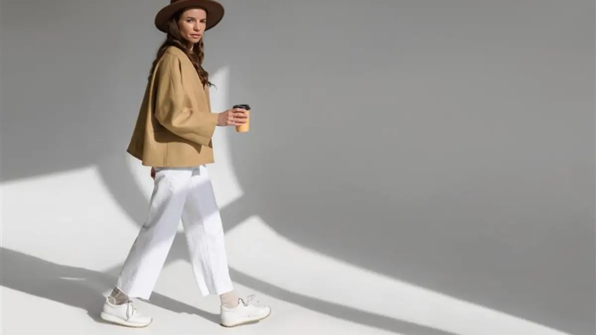 Frau trägt weiße Sneaker.