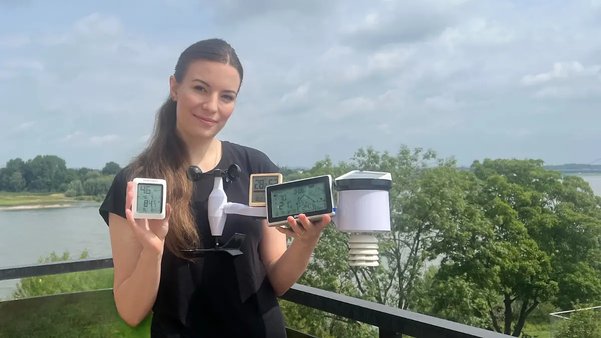 RTL-Reporterin Isabelle Kurz hält die getesteten Wetterstation in ihren Hände. Sie steht auf ihrem Balkon
