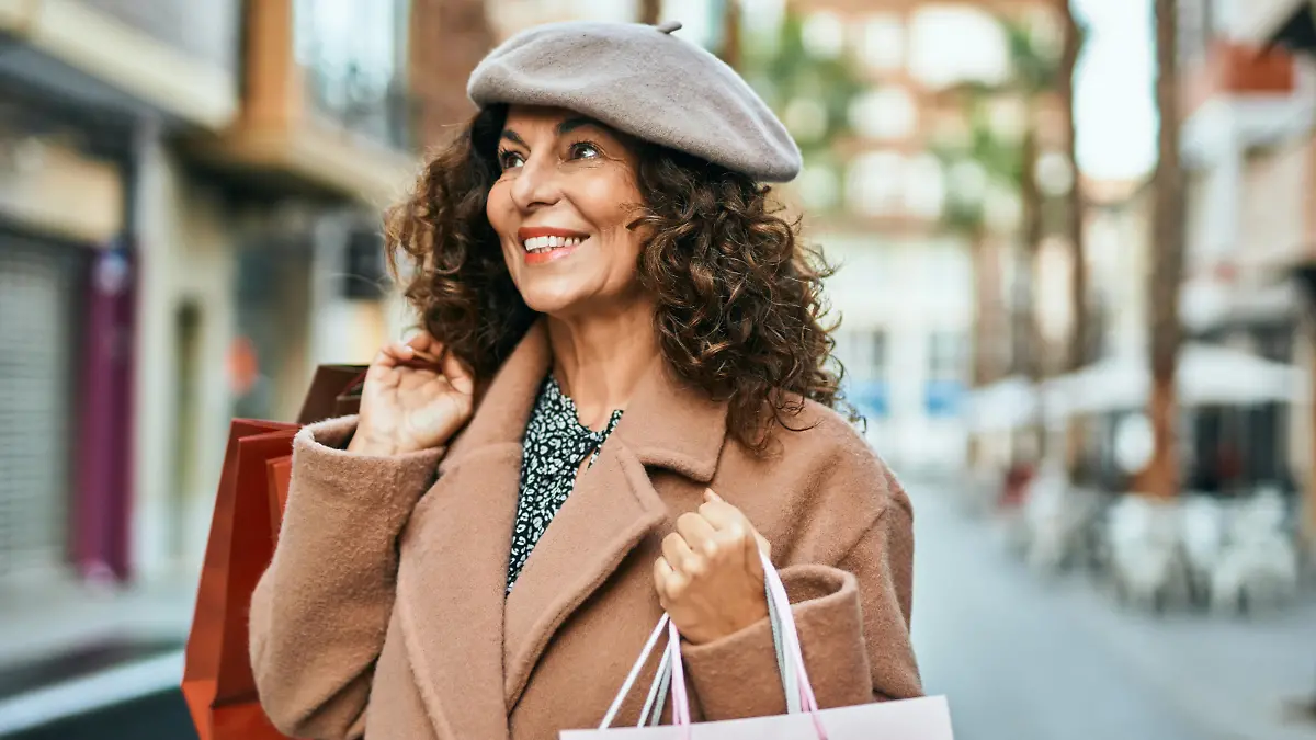 Middle age hispanic woman smiling happy shopping at the city.